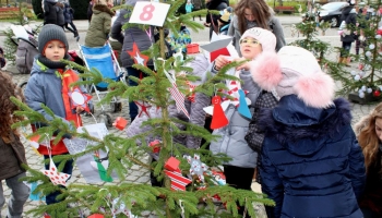 dzieci dekorują choinki