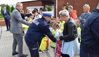 policjant zakłada kamizelkę uczniowi