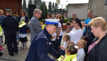 policjant zakłada kamizelkę uczniowi