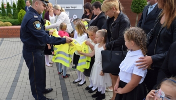 strażnik miejski zakłada kamizelkę uczniowi