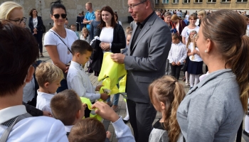 zastępca burmistrza wręcza kamizelki odblaskowe pierwszoklasistom