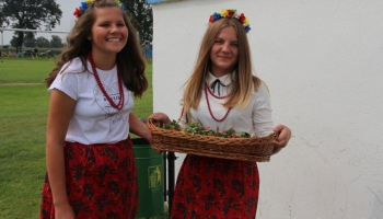 dwie dziewczyny w stroju ludowym witające gości