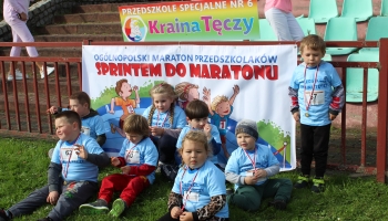 Dzieci z Przedszkola "Kraina Tęczy" na tle baneru Ogólnopolskiego Maratonu Przedszkolaków