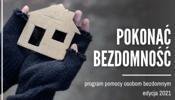 ręka bezdomnego trzymająca papierowy domek