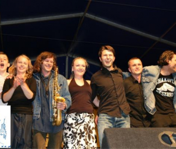 grupa ludzi na scenie po występach