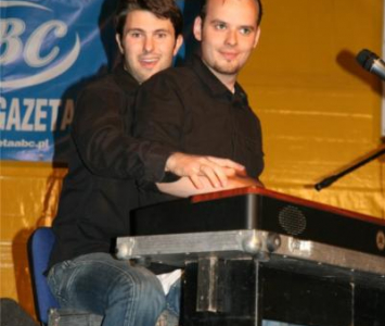 dwójka mężczyzna siedząca na scenie przy organach