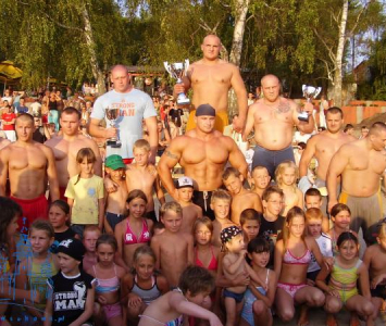 grupa strongmenów wraz z dziećmi pozująca do zdjęcia