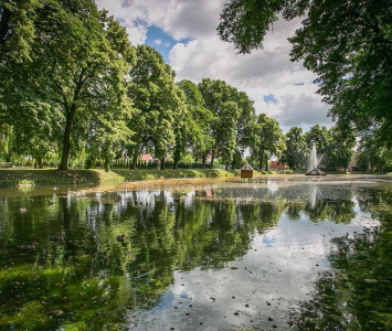 staw z drzewami na brzegach oraz fontanną na środku
