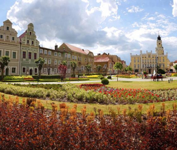 plac z zabytkowymi kamienicami i roślinnymi nasadzeniami